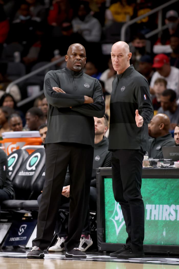 Atlanta Hawks head coach Nate McMillan confers with assistant coach Chris Jent during their game against the LA Clippers at State Farm Arena.